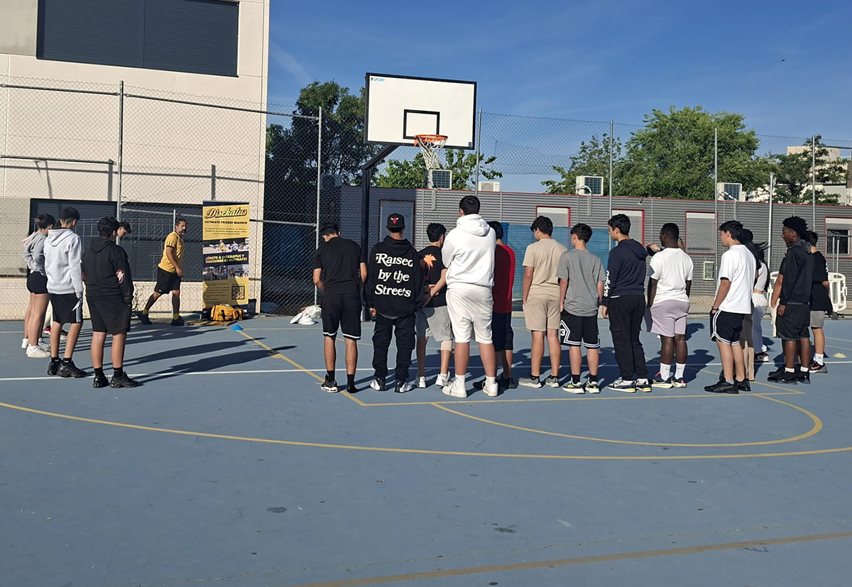 Niños jugando ultimate frisbee en el patio del colegio
